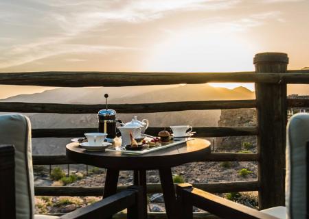 alila jabal akhdar location di lusso in oman momento di relax su terrazza con vista sui monti dove uscire per escursioni su vie ferrate, trekking e visite ai forti